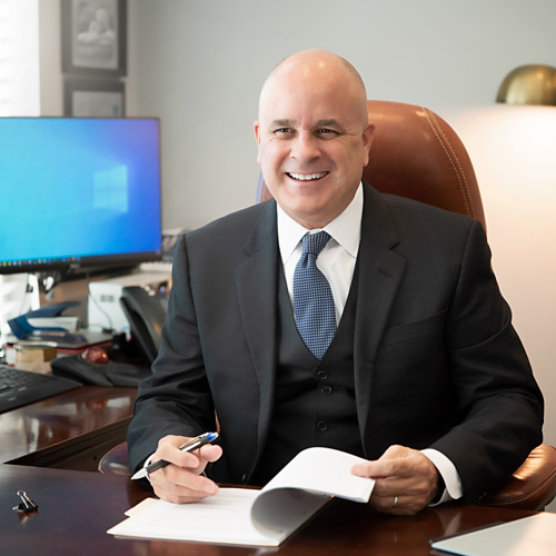 attorney Jim Davis smiling at his office desk